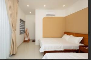 a bedroom with two beds and a window at Homestay Mai Biển Ninh Chử in Thôn Mỹ Nghĩa