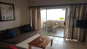 a living room with a couch and a table at Sunrise Beach Resort in Amanzimtoti