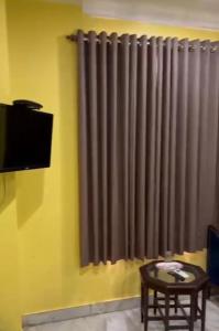 Una sala de estar con una ventana con una cortina gris. en Hotel GP Stays, en Calcuta
