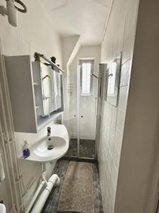 a white bathroom with a sink and a shower at Lumineux & cosy accès Paris Versailles La Défense in Suresnes
