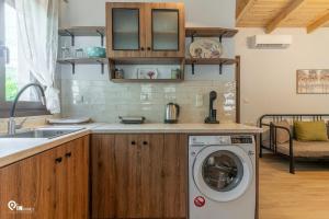 a kitchen with a washing machine and a sink at Myrtali's - Tzoumerka Mountain View Retreat 