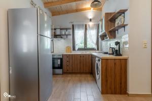 a kitchen with a stainless steel refrigerator and wooden cabinets at Myrtali's - Tzoumerka Mountain View Retreat 
