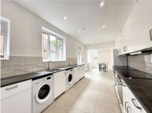 a white kitchen with a washer and dryer at City Stays at St Patricks - Private Ensuites in Coventry