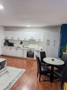 a kitchen with white cabinets and a table and chairs at Stan Setaliste in Brčko +20 photos