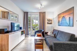 a living room with a couch and a tv at Residenz am Balmer See - BS 10 mit Wellnessbereich in Balm