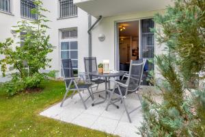a patio with a table and chairs in a yard at Residenz am Balmer See - BS 10 mit Wellnessbereich in Balm