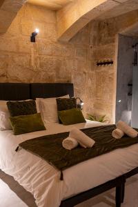 a bedroom with a large bed with towels on it at Zekka House in Valletta