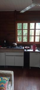 a kitchen with a stove and some windows at Casa do canto das ondas in Bombinhas