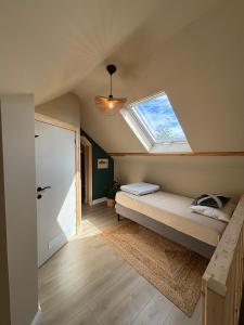 a room with a bed and a skylight at Fermette Ardennaise typique in Wanlin
