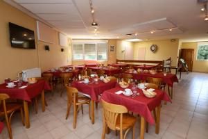 a restaurant with tables and chairs with red table cloth at Hotel Le Lagon in Rochefort-du-Gard