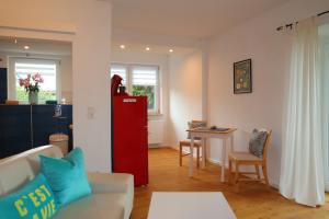 a living room with a red refrigerator and a table at Ferienwohnung Am Deich in Kappeler Niederstrich