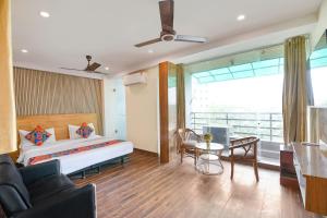 Un dormitorio con una cama, una mesa y un sofá. en FabExpress Hari Nagar Ashram, en Nueva Delhi