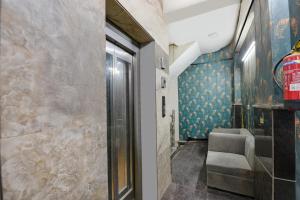 pasillo con puerta y silla en una habitación en FabExpress Hari Nagar Ashram, en Nueva Delhi