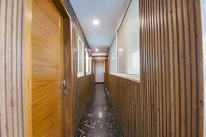 pasillo con paredes de madera y ventana en FabExpress Hari Nagar Ashram, en Nueva Delhi