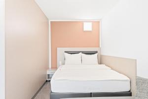 sypialnia z łóżkiem z białą pościelą w obiekcie Meri Boarding Europaplatz w Stuttgarcie