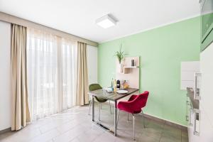 jadalnia z zielonymi ścianami oraz stołem i krzesłami w obiekcie Meri Boarding Europaplatz w Stuttgarcie