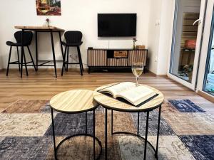 a living room with two tables with a book and a wine glass at Apartmán MINOR in Slavkov pod Hostýnem