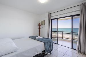 a bedroom with a bed and a view of the ocean at Apto Beira-Mar c/ Vista p/ Praia VTE0301 in Meia Praia
