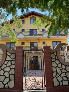 a building with a gate in front of it at Pensiunea Bianca in Murighiol