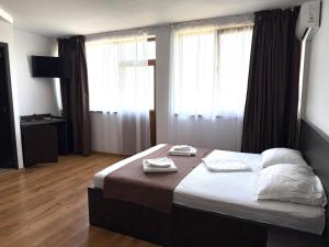 a bedroom with a bed with two towels on it at Pensiunea Bianca in Murighiol