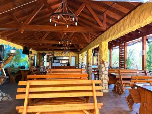 a group of wooden benches in a restaurant at Pensiunea Bianca in Murighiol