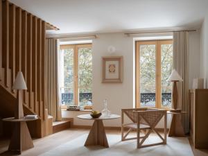 a living room with windows and a table and chairs at Elysée Montmartre Hotel in Paris