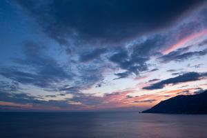 una puesta de sol sobre el océano con un cielo nublado en Nonna Titti, en Amalfi