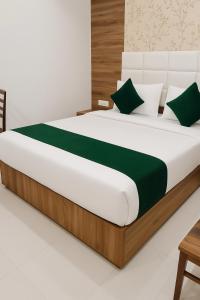 a bedroom with a large bed with green pillows at Hotel Himanshi Executive in Mumbai