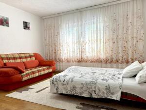 a bedroom with a bed and a couch at Podujeva - Home Sweet Home in Orllan