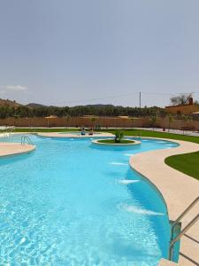 a swimming pool with blue water in a park at The terraces in Bácor