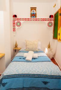 a bedroom with a blue and white bed at Riad KASBAH in Tangier