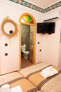 a bedroom with two beds and a bathroom with a mirror at Riad KASBAH in Tangier +73 photos