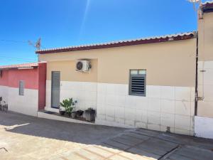 a house with a red and white wall at Chalé 2 novo mel in Areia Branca