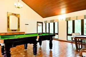 a pool table in a room with windows at Villa Vaasa Luxury Homestay in Avathi
