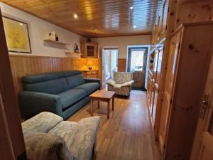 a living room with a blue couch and a table at Coldemies apartment in Alleghe +23 photos