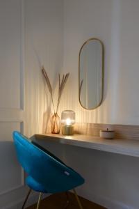 a blue chair sitting on a desk with a mirror at Cosmo Lake City Apartments in Como
