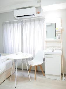 Habitación con mesa blanca y silla blanca en 9stay蔵前, en Tokio 62 fotos más