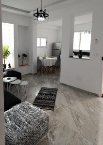 a living room with a table and chairs and a white room at charming bright house la marsa in Dar Tahar Zaouch
