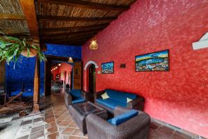 a living room with red walls and leather furniture at Hotel Casa del Consulado in Granada