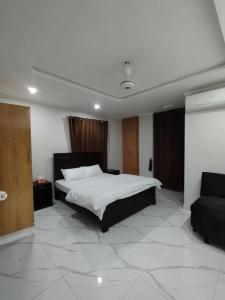 2-Bedroom Apartment near Islamabad International Airport Free Airport Pick and Drop في اسلام اباد: غرفة نوم بها سرير كبير وأريكة