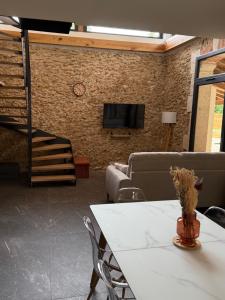een woonkamer met een tafel, een bank en een tv bij Gîte Domaine d'Hybère in Lucbardez-et-Bargues