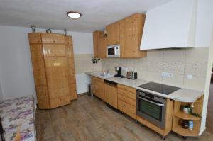 a kitchen with wooden cabinets and a counter top at Casa Muntilor Prejba in Rau Sadului