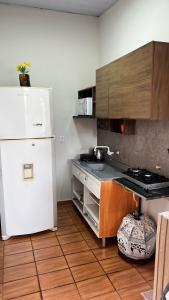a kitchen with a white refrigerator and wooden cabinets at Casa próxima ao Centro de Foz in Foz do Iguaçu