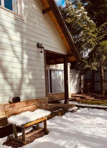 ławka siedząca przed domem w śniegu w obiekcie La cabaña del botánico w mieście Bariloche