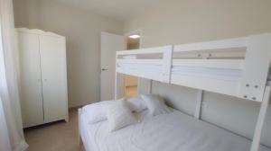 ein weißes Schlafzimmer mit einem Etagenbett mit zwei Kissen in der Unterkunft Casa Serena in Roquetas de Mar