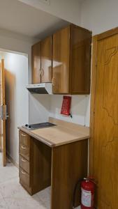 a kitchen with wooden cabinets and a counter top at برج الجوار السكني أجياد المصافي Jiwar Tower Ajyad Al Masafi in Al Gharīth