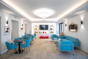 a waiting room with blue chairs and a table at Hotel Palazzo Antonietta in San Marco di Castellabate