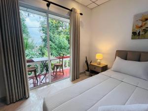 a bedroom with a bed and a view of a balcony at Kandy View Stay in Kandy