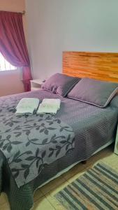 a bedroom with a bed with two towels on it at Abu Rosa in Villa Elisa