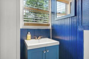 a blue bathroom with a sink and a window at 2 Homes Retreat Game Rooms & Fire Pit Winni in Moultonborough +128 photos